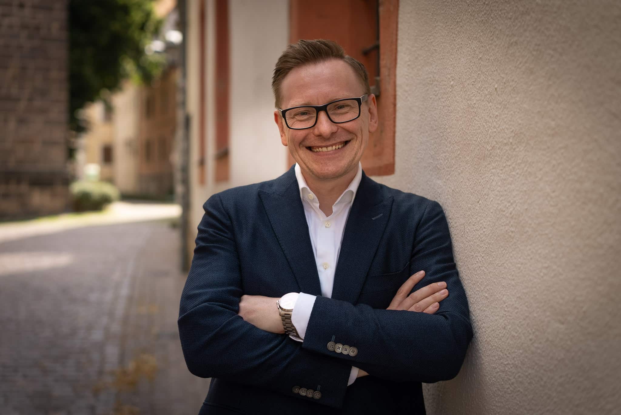 Ronald Brod im Anzug vor einem Altbau